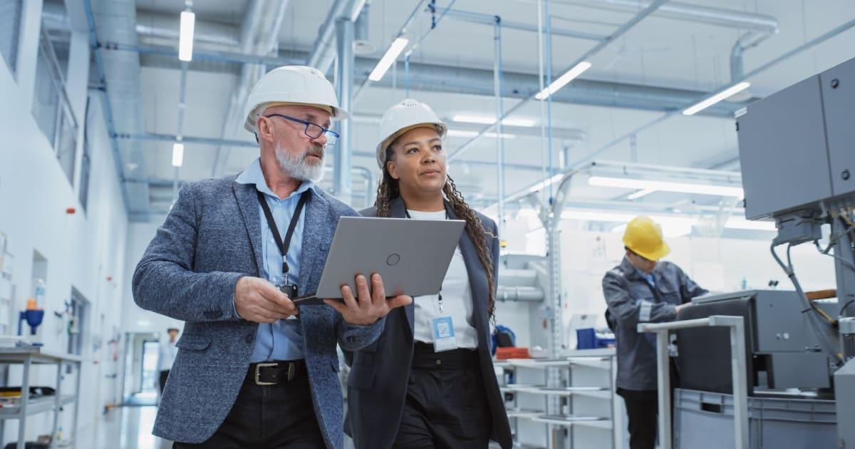 Warehouse managers reviewing operations with a laptop