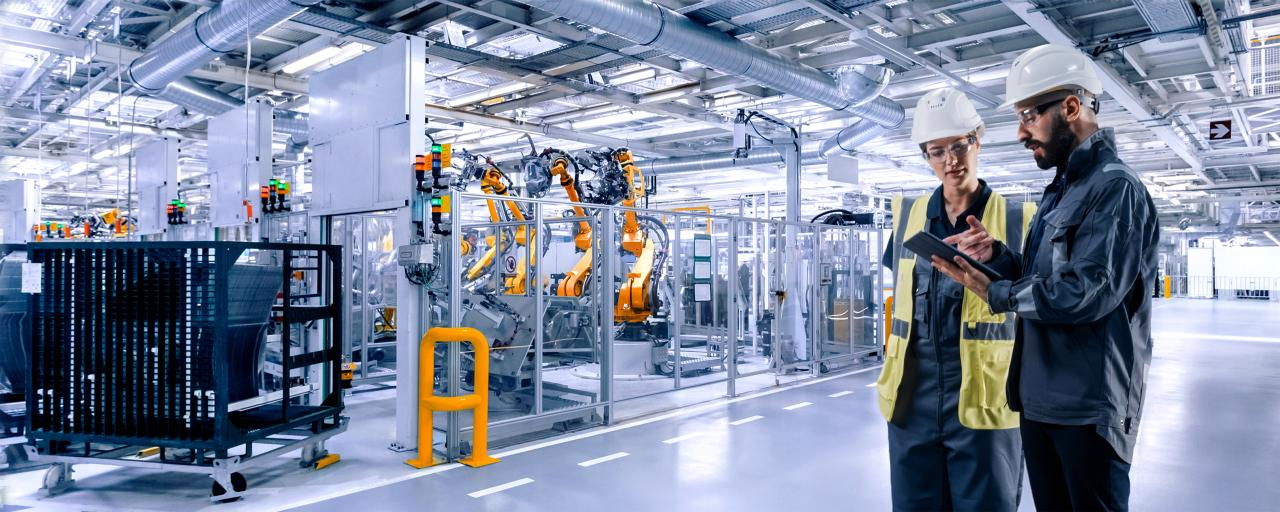 Engineers reviewing plans on a manufacturing floor