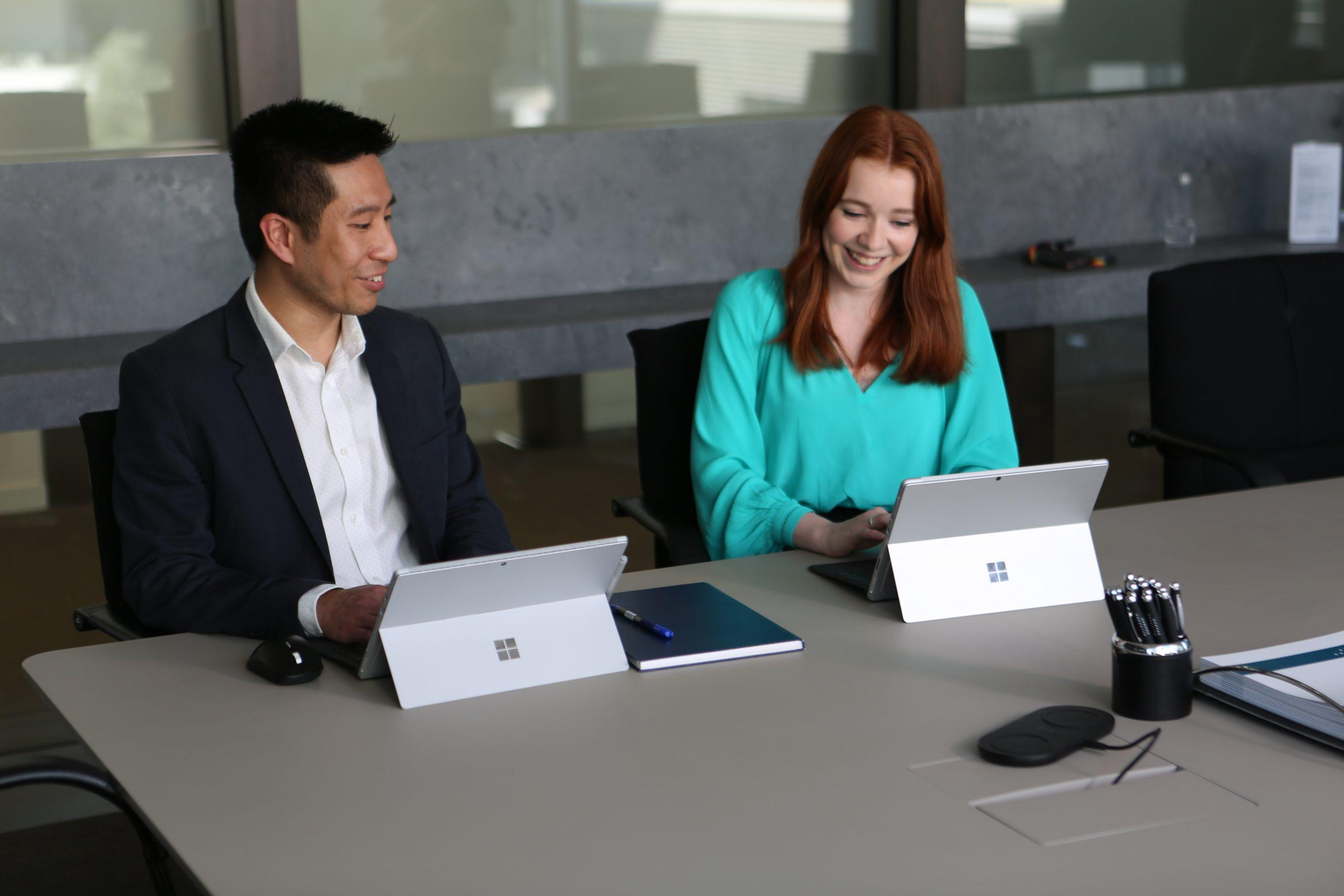 Two colleagues collaborating with tablets in a modern workspace
